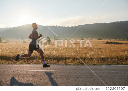 Determined Stride: Athletic Man Embarks on Marathon Preparation with Resolve. 112805507