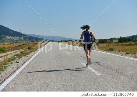 A determined woman athlete trains for success in the morning sun. A determined woman athlete trains for success in the morning sun. 112805746