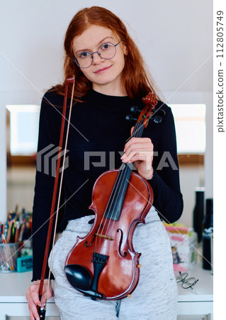 Stunning Redhead Musician Poses with Violin in Captivating Portrait Stunning Redhead Musician Poses with Violin in Captivating Portrait 112805749