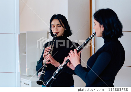 Graceful Brunette Musician Posing with Clarinet on White Background Graceful Brunette Musician Posing with Clarinet on White Background 112805788