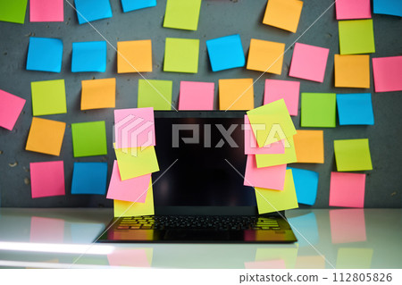 Office workplace with laptop and blank colorful sticky notes reminders 112805826