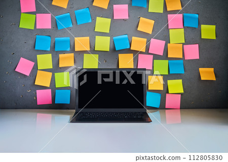 Modern laptop and blank colorful sticky notes on wall background 112805830