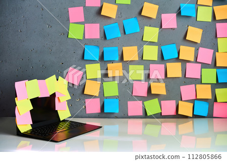 Office workplace with laptop and blank colorful sticky notes reminders Office workplace with laptop and blank colorful sticky notes reminders 112805866