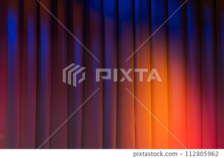 Closed theatrical curtain with colorful spot lights of stage illumination 112805962