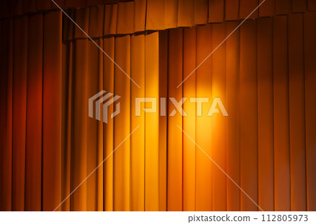 Scenic curtains with gold colored spot lights illumination, background 112805973