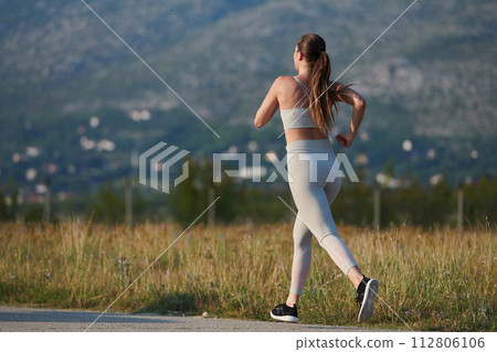 Solo Stride: Determined Athlete Woman Embarks on Fitness Journey for Marathon Preparation. Solo Stride: Determined Athlete Woman Embarks on Fitness Journey for Marathon Preparation. 112806106