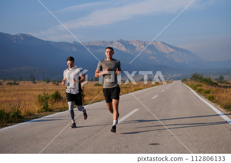 A group of friends maintains a healthy lifestyle by running outdoors on a sunny day, bonding over fitness and enjoying the energizing effects of exercise and nature 112806133