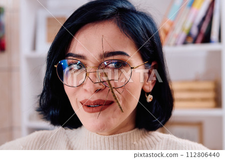 Young Woman Captured in a Beautiful Moment with Her Stick Insect (Medauroidea Extradentata) Young Woman Captured in a Beautiful Moment with Her Stick Insect (Medauroidea Extradentata) 112806440