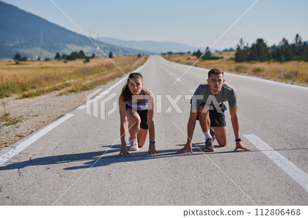 Energized by the beauty of nature, a couple powers through their morning run, their bodies and spirits invigorated. 112806468