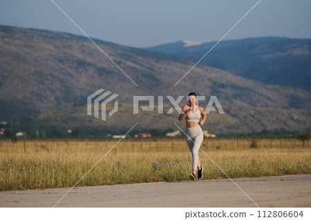 A determined woman athlete trains for success in the morning sun. 112806604