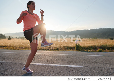 Determined Stretch: Athletic Woman Embraces Post-Run Flexibility in Nature. 112806631