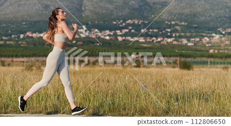 Solo Stride: Determined Athlete Woman Embarks on Fitness Journey for Marathon Preparation. Solo Stride: Determined Athlete Woman Embarks on Fitness Journey for Marathon Preparation. 112806650