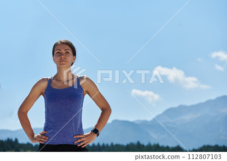 Determined Stretch: Athletic Woman Embraces Post-Run Flexibility in Nature. 112807103