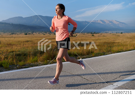 Determined Dawn: Confident and Motivated Athlete Embarks on Sunrise Run. 112807251