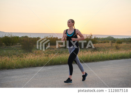 Solo Stride: Determined Athlete Woman Embarks on Fitness Journey for Marathon Preparation. Solo Stride: Determined Athlete Woman Embarks on Fitness Journey for Marathon Preparation. 112807518