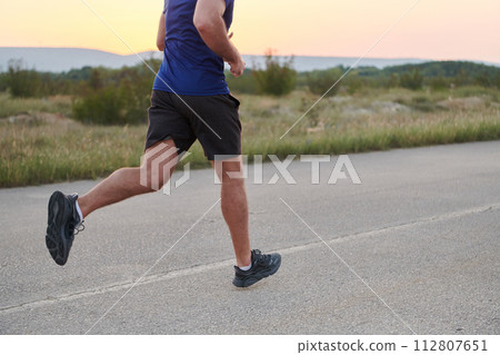 A dedicated marathon runner pushes himself to the limit in training. 112807651