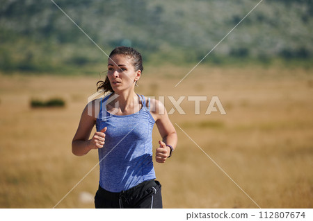 Solo Stride: Determined Athlete Woman Embarks on Fitness Journey for Marathon Preparation. Solo Stride: Determined Athlete Woman Embarks on Fitness Journey for Marathon Preparation. 112807674