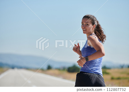 A determined woman athlete trains for success in the morning sun. 112807732