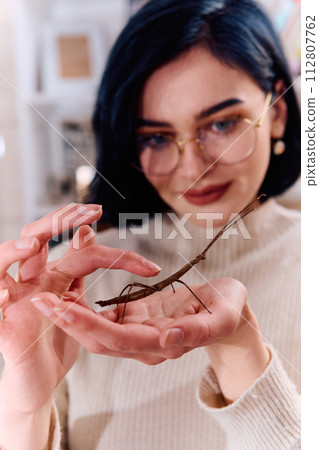 Young Woman Captured in a Beautiful Moment with Her Stick Insect (Medauroidea Extradentata) 112807762