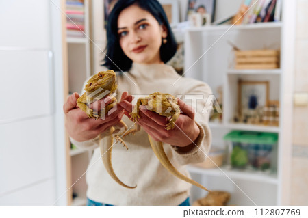 Beautiful Woman Posing with Her Two Adorable Bearded Dragon Pets 112807769
