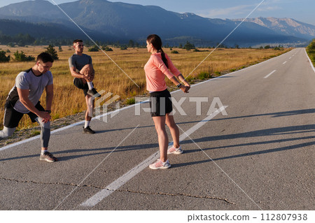Diverse Athletes Prepare: Dynamic Group Warms Up for Morning Run. 112807938