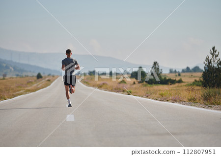 A dedicated marathon runner pushes himself to the limit in training. 112807951