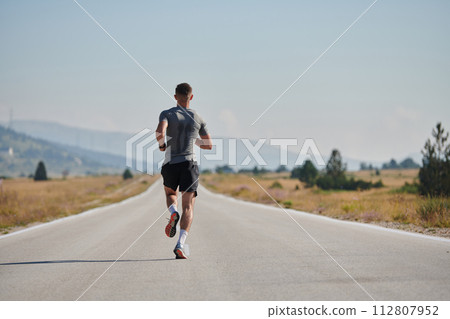 A dedicated marathon runner pushes himself to the limit in training. 112807952
