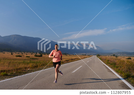 Determined Dawn: Confident and Motivated Athlete Embarks on Sunrise Run. 112807955