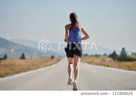 A determined woman athlete trains for success in the morning sun. 112808026