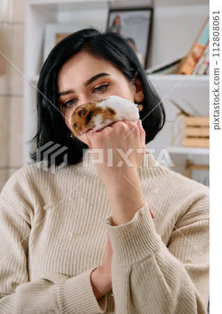 A Black-Haired Beauty Enjoys a Cozy Day at Home with Her Pet Mouse 112808061