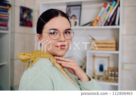Beautiful Woman Posing with Her Adorable Bearded Dragon Pets Beautiful Woman Posing with Her Adorable Bearded Dragon Pets 112808463