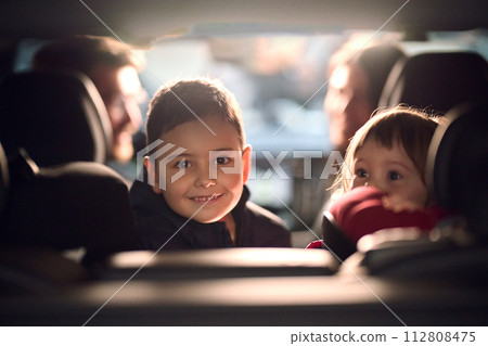 A young brother and sister enjoying a car ride together, immersed in the adventure of travel 112808475