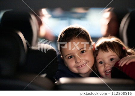 A young brother and sister enjoying a car ride together, immersed in the adventure of travel 112808516