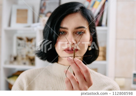 Young Woman Captured in a Beautiful Moment with Her Stick Insect (Medauroidea Extradentata) 112808598