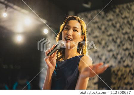 一個女人熱情地唱著一首歌 112808687