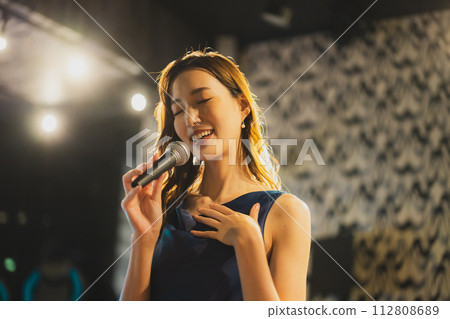 A woman singing a song passionately 112808689