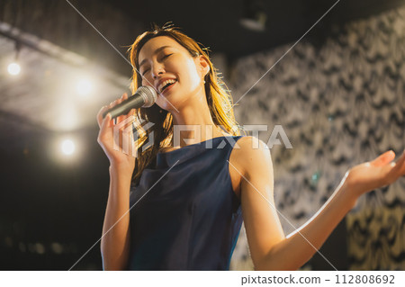 A woman singing a song passionately 112808692