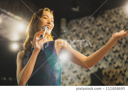 一個女人熱情地唱著一首歌 112808695