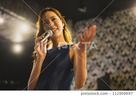 A woman singing a song passionately 112808697