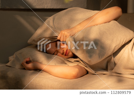 Woman Disturbed by Noise While Trying to Sleep  112809579