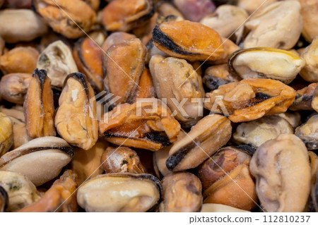 Frozen mussels. Seafood on the counter. Fish market. Close-up shooting of seafood. Photo of mussels in a supermarket. Wholesale of fish. Peeled mussels 112810237