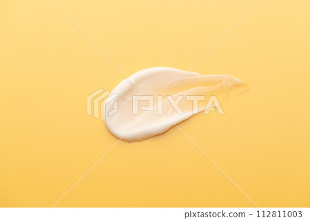 Skincare cream smear on yellow background. Cosmetic lotion swatch texture of sunscreen, face cream, body moisturiser and hair conditioner. Beauty and cosmetic product. Skincare cream smear on yellow background. Cosmetic lotion swatch texture of sunscreen, face cream, body moisturiser and hair conditioner. Beauty and cosmetic product. 112811003