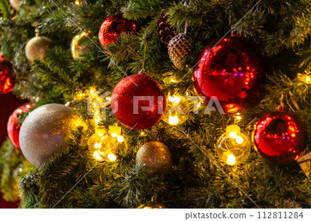 Beautiful Christmas ornament hung on lit tree 112811284