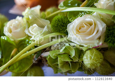 Freshness in Bloom: Delicate Roses and Lush Greenery in a Floral Arrangement 112811640