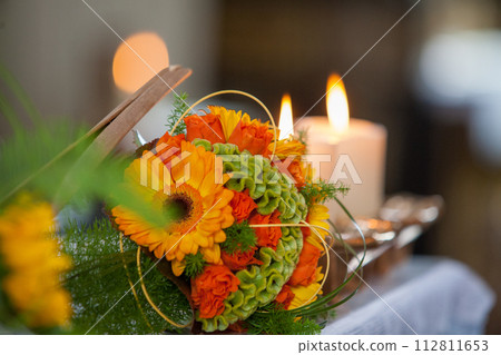 Warm Glow of Candlelight Accentuating a Floral Centerpiece 112811653