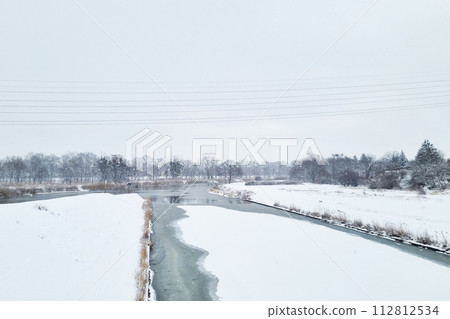 Snow Covered Field With River Running Through Snow Covered Field With River Running Through 112812534