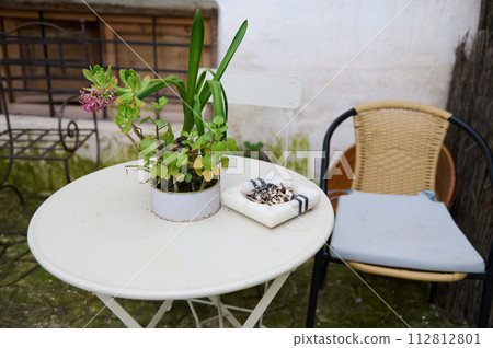 Still life with marble ashtray with cigarette butts on table with chair in garden. The concept of lung cancer diseases 112812801