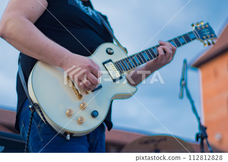 musician on stage playing white guitar, close-up musician on stage playing white guitar, close-up 112812828