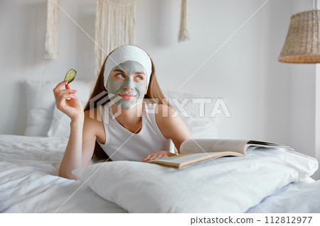 Portrait of young smiling woman enjoying home spa procedure 112812977