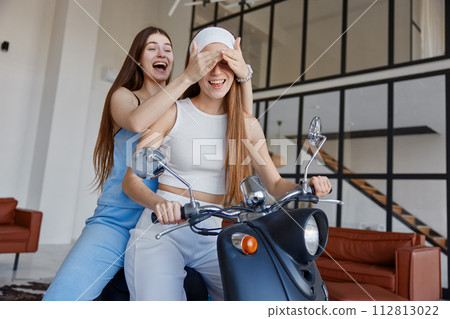 Two carefree girls having fun while sitting on motorbike 112813022